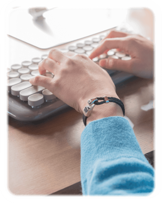 다시 시작 팔찌를 착용하고 키보드를 조작하는 손
