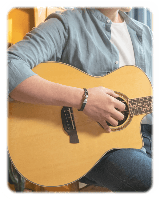 다시 시작 팔찌를 착용하고 기타를 치는 손